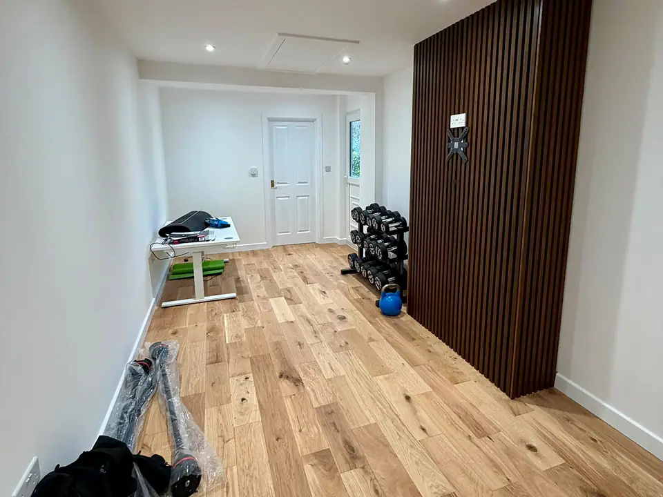 Garage converted to a home gym and office with a slatted panel